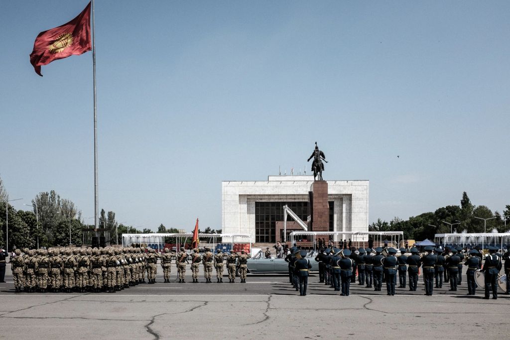 Kyrgyzstan's Chief of the General Staff Asanbek Alymkozhoev drives by to greet Kyrgyz troops (left) and Russian troops.