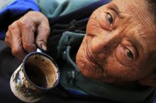 Idős Lisu asszony portréja
A Dél-Kínai Yunnan tartomány Weixi megyéjének Lisu népcsoport lakói körében nagyon népszerű a pipázás, minek következtében az ujjak befeketednek